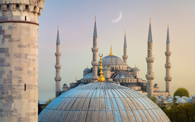 Crescent moon over Blue Mosque and Firuz Agha Mosque at dawn in Istanbul, Turkey
