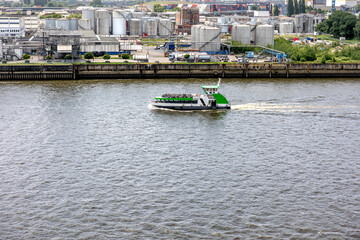 Ferry on river. Industrial shore. Urban landscape.