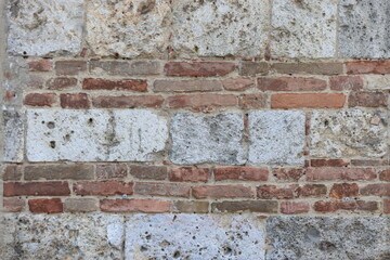A detailed close-up of an old red brick wall in Siena, Italy