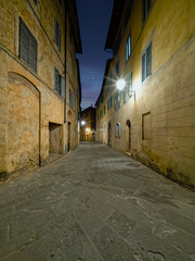 Twilight casts a soft glow over the narrow alleys of Siena,  where historic buildings and elegant facades create an emotive and timeless urban scene. Travel to Tuscany, Italy.