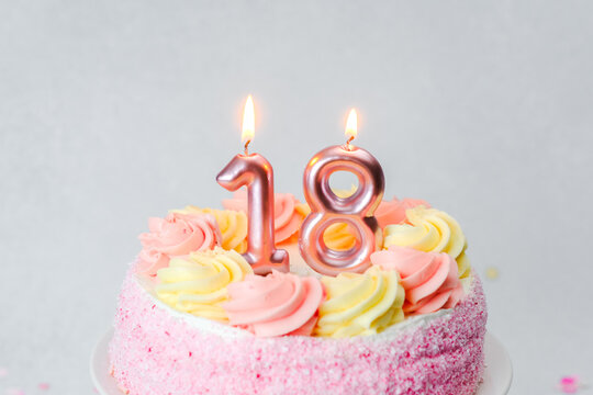 Birthday cake for 18th birthday celebration with pink frosting and candles