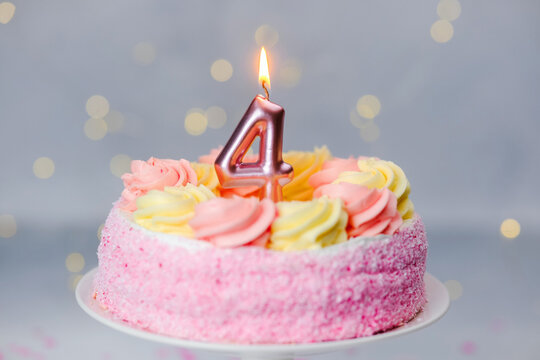 Pink frosted birthday cake with one candle for the 4th birthday
