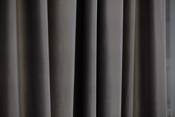 Soft gray curtains gently draping in a modern living space under natural light