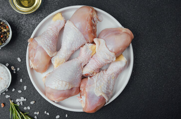 Chicken drumsticks raw with spices and herbs on white plate