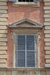 Old windows with shutters on an old house in Siena, Italy