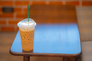 Close up glass ice coffee on wooden table at coffee shop in copy space concept.
