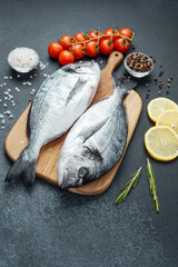 Dorado  fish with  tomatoes,  lemon and spices on cutting board