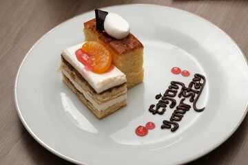 A plate with two types of cakes decorated with fruit, chocolate writing, and a warm message 