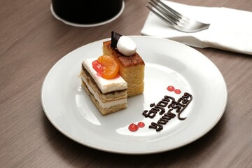 A plate with two types of cakes decorated with fruit, chocolate writing, and a warm message 