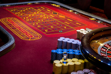 Roulette table in casino. Casino American Roulette gambling table with a wheel and playing chips on...