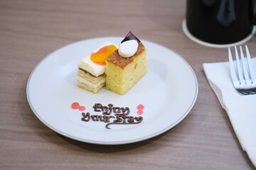 A plate with two types of cakes decorated with fruit, chocolate writing, and a warm message 