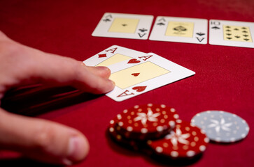 Fototapeta na wymiar Two aces and big stake on red felt. Gaming cards in hand. Poker chips with two aces on background. Poker chips with two aces on green background.