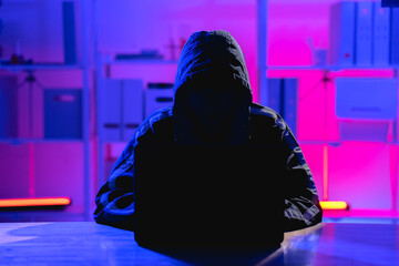 Dark Figure in Hoodie Engaged in Cybersecurity Activities at Night
