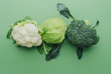 Broccoliб cabbage and cauliflower mix on green background healthy diet concept