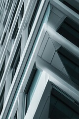Obraz premium Abstract architecture, close-up of a building's exterior wall, sharp edges, geometric shapes, high-contrast lighting, cool tones, sharp shadows, architectural photography, modern cityscape background.