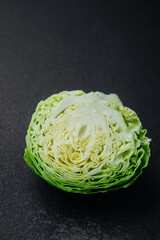 Detailed texture of halved cabbage on black surface