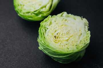Two cut cabbage halves on dark background close detail