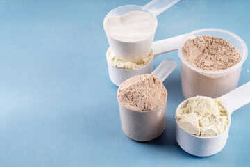 Different protein powders flavors in plastic scoops
