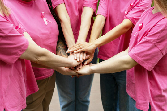 Volunteers Joining Hands Showing Support For Breast Cancer Awareness