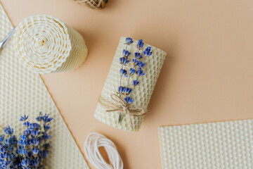 Beeswax candle making set with lavender and tools on beige background