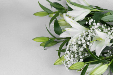 Beautiful bouquet of white lilies and delicate greens arranged artfully