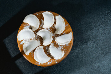 Dumplings arranged on a wooden board ready for cooking in a cozy kitchen