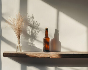 A bottle of beer stands on a wooden shelf against a white wall. Shadows from the window and plants. Empty space on the side. Sunny day, beautiful play of light. Bottles of delicious beer