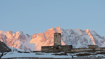 Snow covered historical Lamaria monastery with Shkhara peak during sunset in Caucasus mountains, Georgia - Powered by Adobe