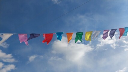 Colorful triangular flags strung across a bright blue sky, adding a festive atmosphere to the scene.