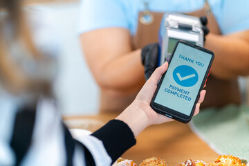 Woman Using Mobile Phone Payment to Transfer Money to bakery Shop Seller.NFC QR code device,payWave,contactless payment code for fast digital transaction,Online banking app on mobile phone,paperless