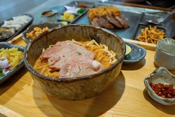 Delicious Pork Noodle Soup with Spices Served in a Rustic Bowl on Wooden Tray