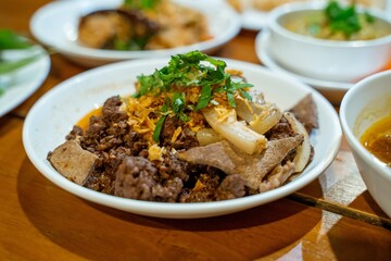 Delicious Spicy Stir fried Pork Liver with Crispy Garlic and Herbs in a White Bowl