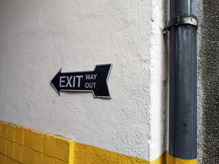 Exit Way Out Blechschild und Zeichen mit Pfeil im amerikanischen Stil in einer Hofeinfahrt im...