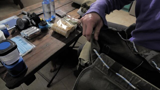 Military Survival Kits. A man collects a backpack with basic necessities in case of war or nuclear threat