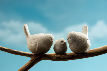 Mother, Father and baby birds perched on branch, symbolizing family love, care, and emotional bonding in nature