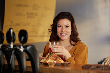 Young woman eat a club sandwich in a bar