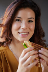 Young woman eat a club sandwich in a bar