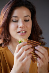 Young woman eat a club sandwich in a bar