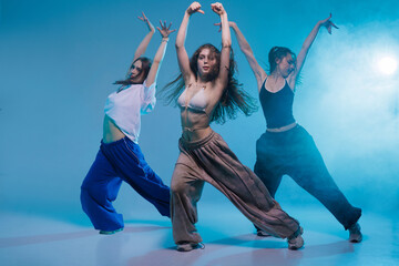 Three Female Dancers Performing Jazz Funk Choreography in Studio with Dramatic Lighting and Energy