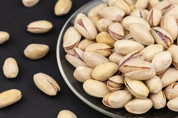 Salted Pistachios for Beer, Macro, on black Background of a Beer Snack of Salted Pistachio Nuts.
