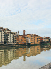 ponte vecchio florence italy with water reflections and cloudy sky