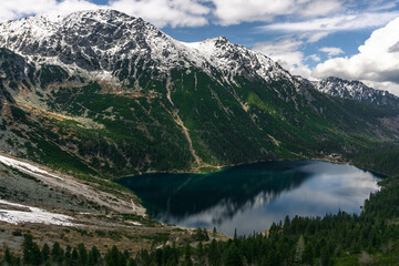 top bird view of glaciar lake surrounded by mountains and forest in national park