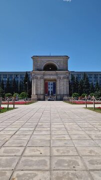 CHISINAU, MOLDOVA - JUNE 20, 2025 Triumphal Arch as popular historical landmark of the capital with the Moldovan Government House in the background