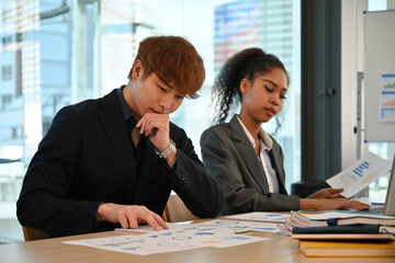 Focused professionals in formal attire working on data presentation and planning, Business Meeting and Data Analysis