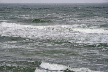 Cold sea background. Small waves on the water surface.