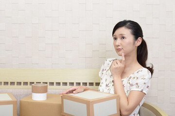 荷物を手に考える女性