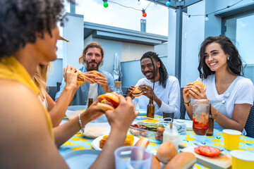 Friends eating burgers at rooftop barbecue party