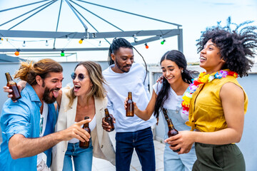 Friends enjoying drinks at rooftop party, celebrating with beer bottles