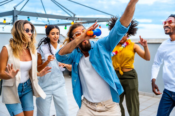 Friends singing and dancing at rooftop party