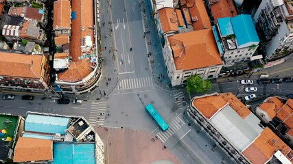 Aerial view of bustling intersection with red-tile houses and busy traffic in historic city landscape